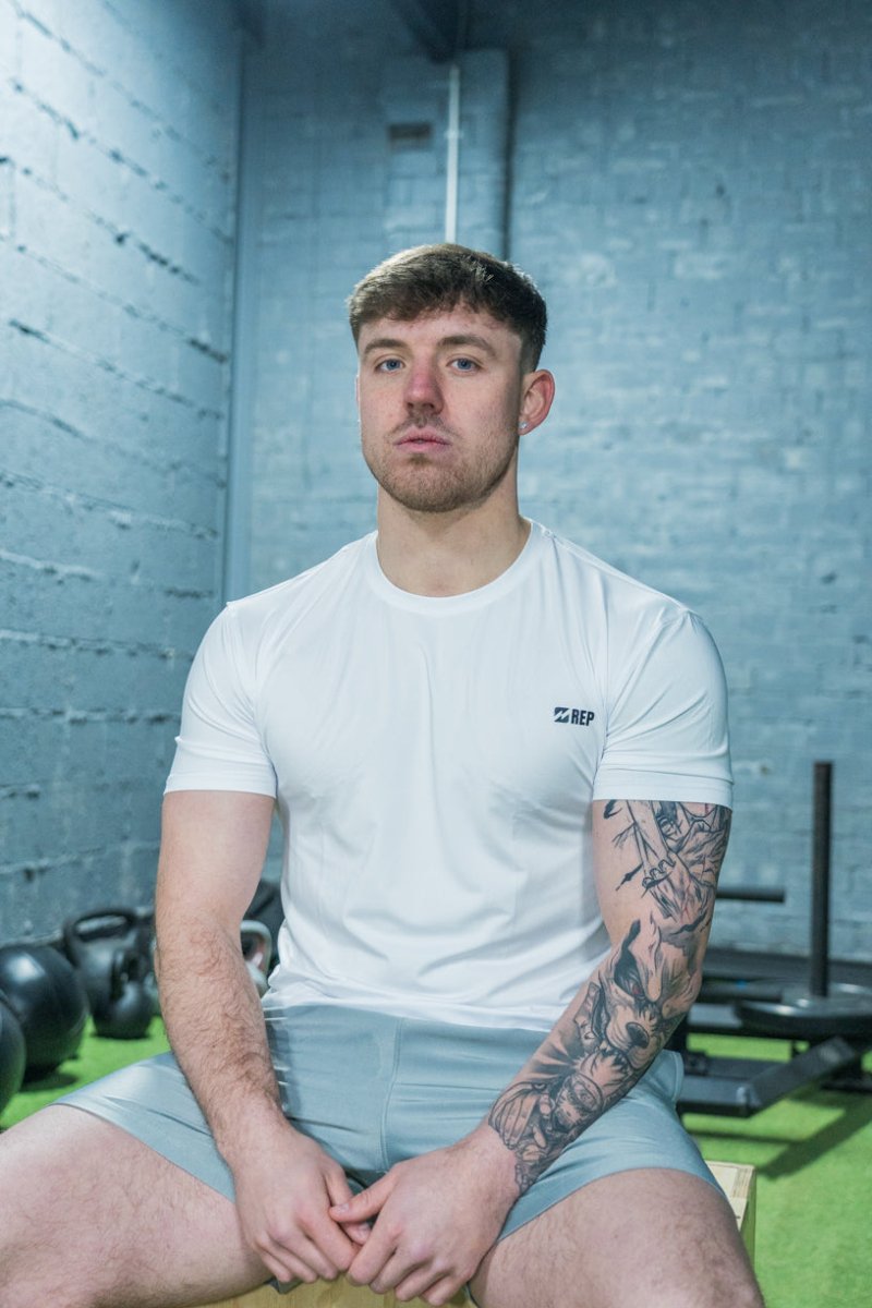 REP white gym top worn during strength training – reps clothing UK, gym tops for men, represent t shirt